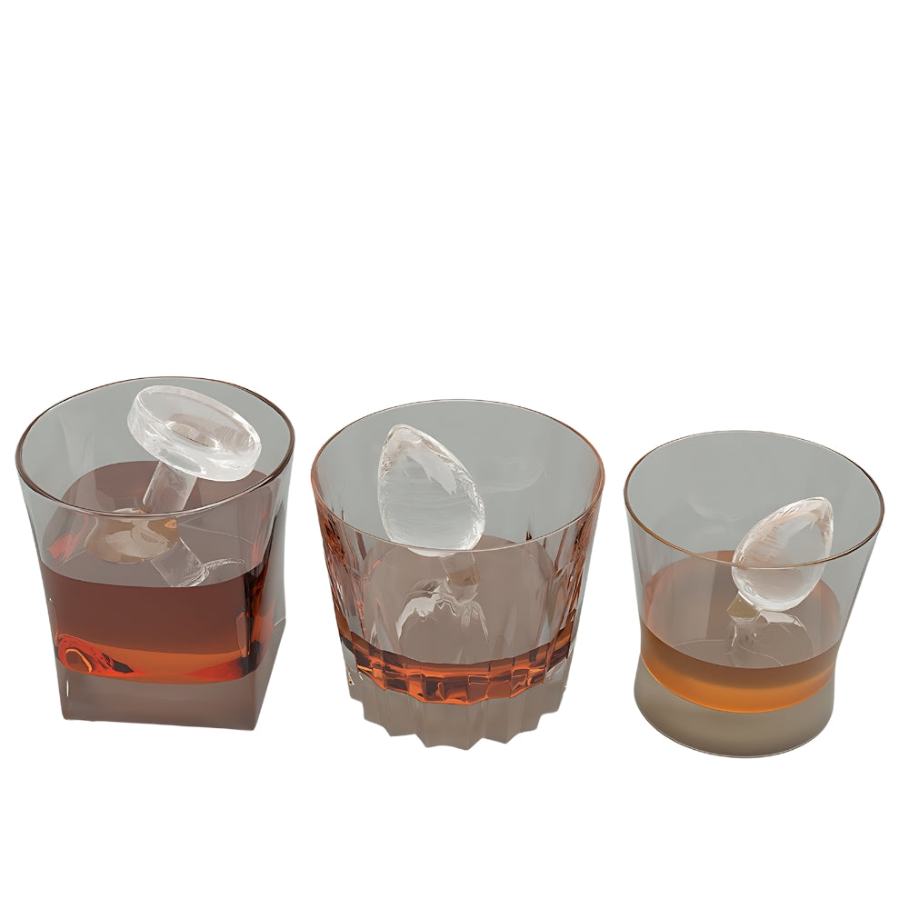 Three glasses with ice cubes and a clear liquid on a white background