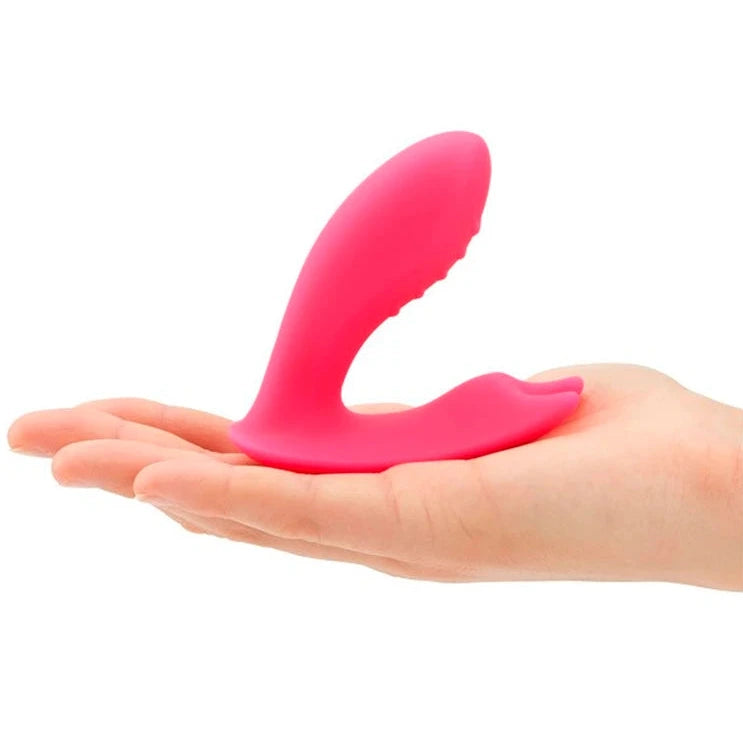 Pink silicone G-Spot Clitoral vibrator on a person's palm against a white background