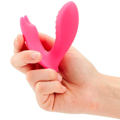 Hand holding a pink silicone vibrator massager against a white background