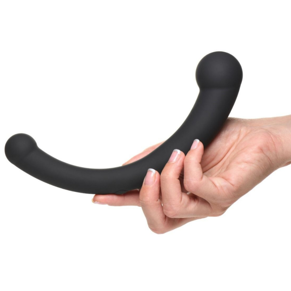 Black curved vibrator held by a hand on a white background