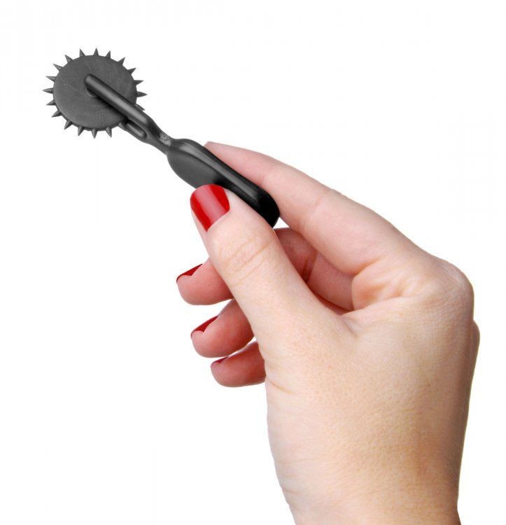 Hand holding a black wheel tool against a white background