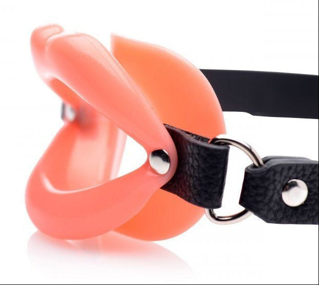 Pink mouth gag with a black strap on a white background