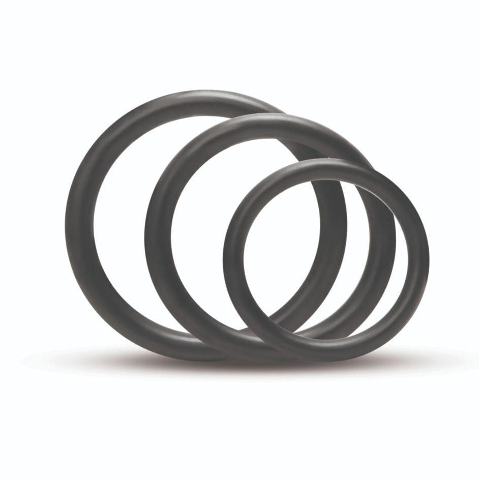Three black rubber O-rings stacked on a white background