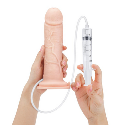 Hand holding a silicone penile sheath with a syringe-like device on a white background
