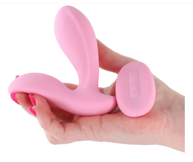 Pink silicone product held in a hand against a white background