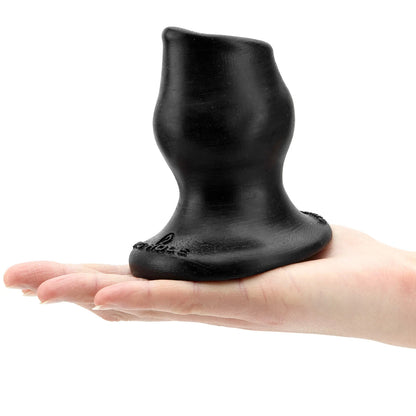 Black silicone anal plug held in a hand on a white background