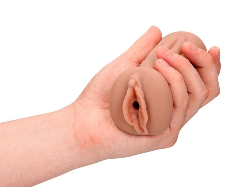 Hand holding a silicone product shaped like a realistic vagina on a white background