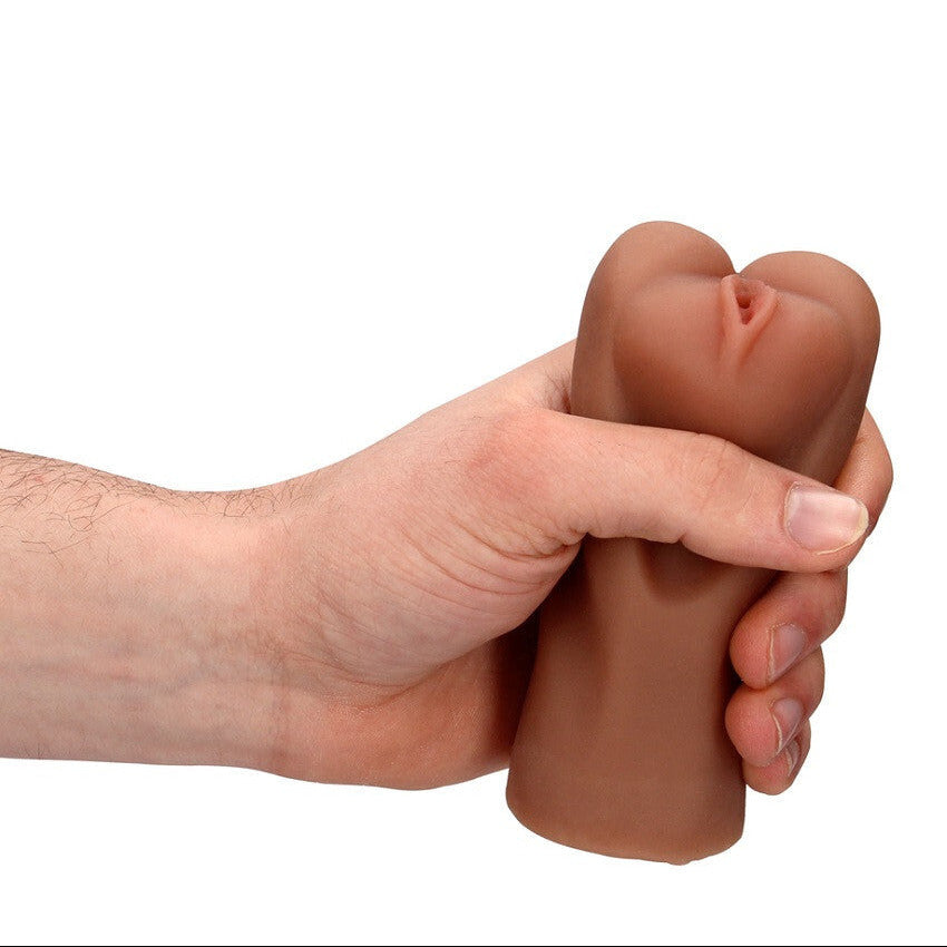 Hand holding a silicone realistic vagina on a white background