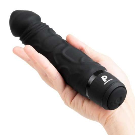 Black handheld dildo vibrator held in a hand on a white background