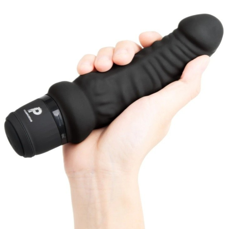 Black handheld realistic dildo vibrator held in a hand on a white background