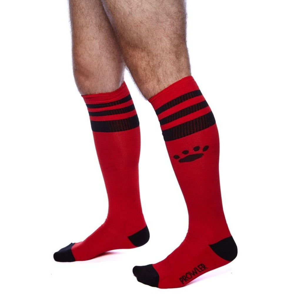 Red socks with black stripes and paw print on a white background