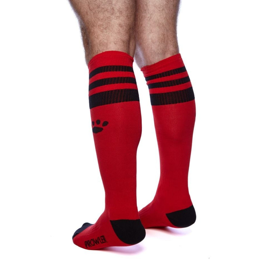 Red knee-high socks with black stripes and paw print on a white background