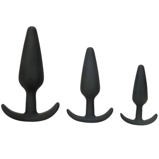 Three black silicone butt plugs of different sizes on a white background