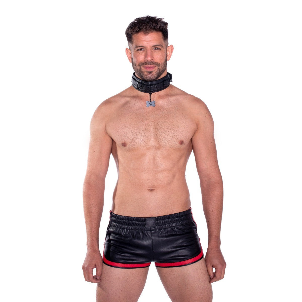 Man wearing black leather shorts with red trim and a black collar on a white background