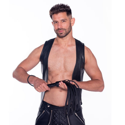 Man wearing a black leather vest with flogger on a white background