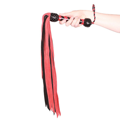 Red and black flogger held by a hand on a white background