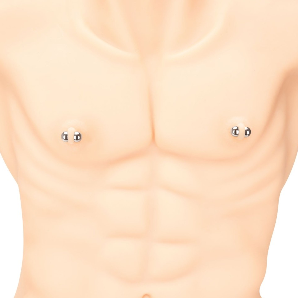 Close-up of a person wearing small magnetic nipple clamps on a plain background