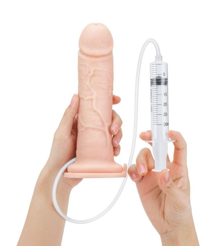 Hand holding a realistic silicone penis with a syringe-like device on a white background