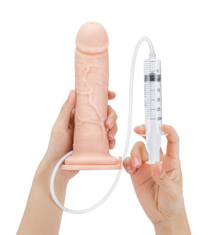 Hand holding a realistic silicone penis with a syringe-like device on a white background