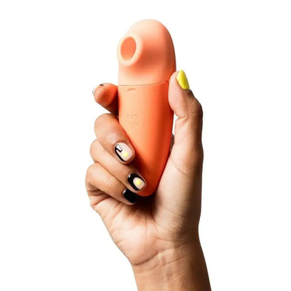 Hand holding an orange silicone product against a white background