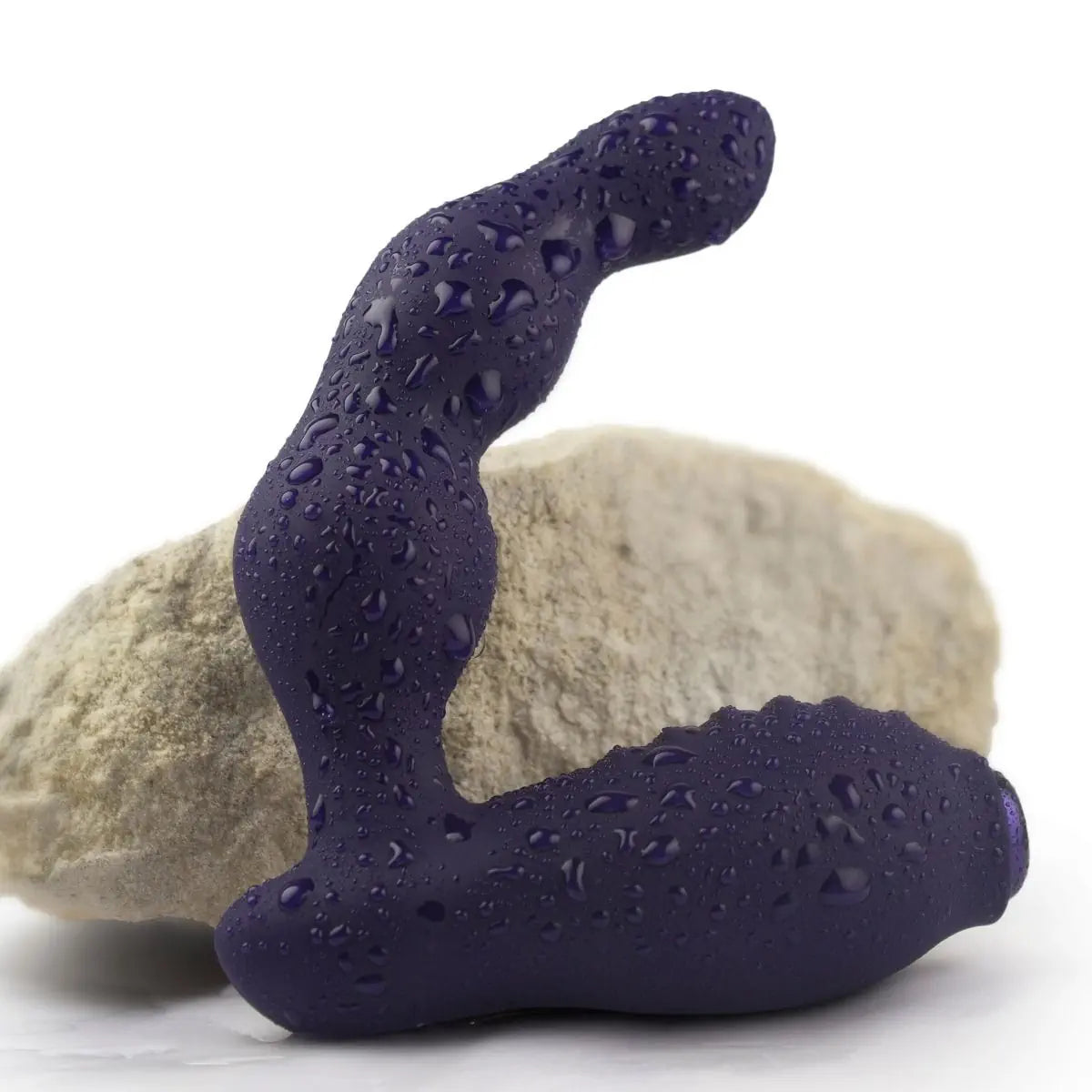 Purple textured anal prostate massager with water droplets on a white background