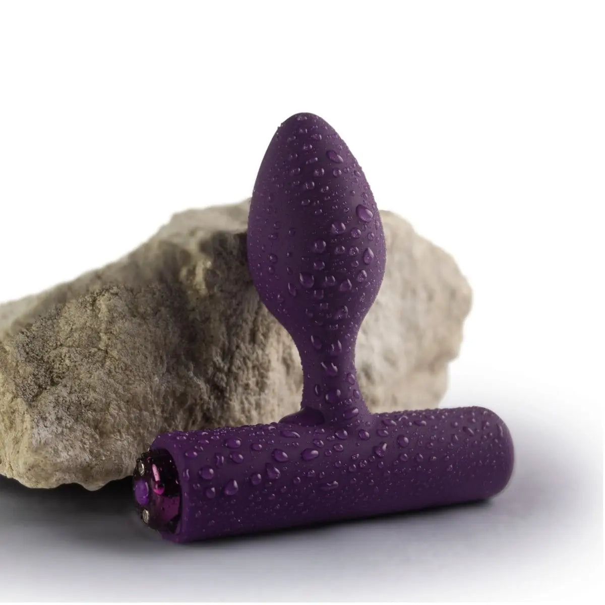 Purple silicone butt plug with water droplets on a white background