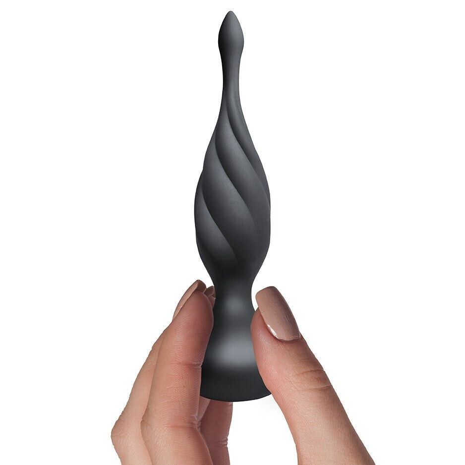 Black spiral anal plug held between fingers on a white background