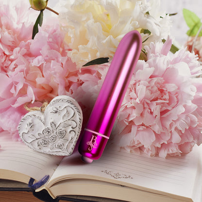 Pink bullet vibrator with decorative heart and floral background