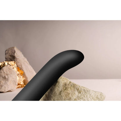 Black curved object on a neutral background with rocks