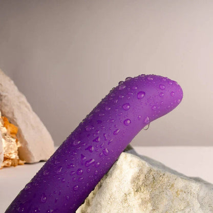 Purple object with water droplets on a neutral background