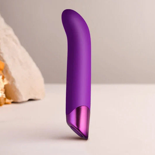 Purple cylindrical massager on a neutral background