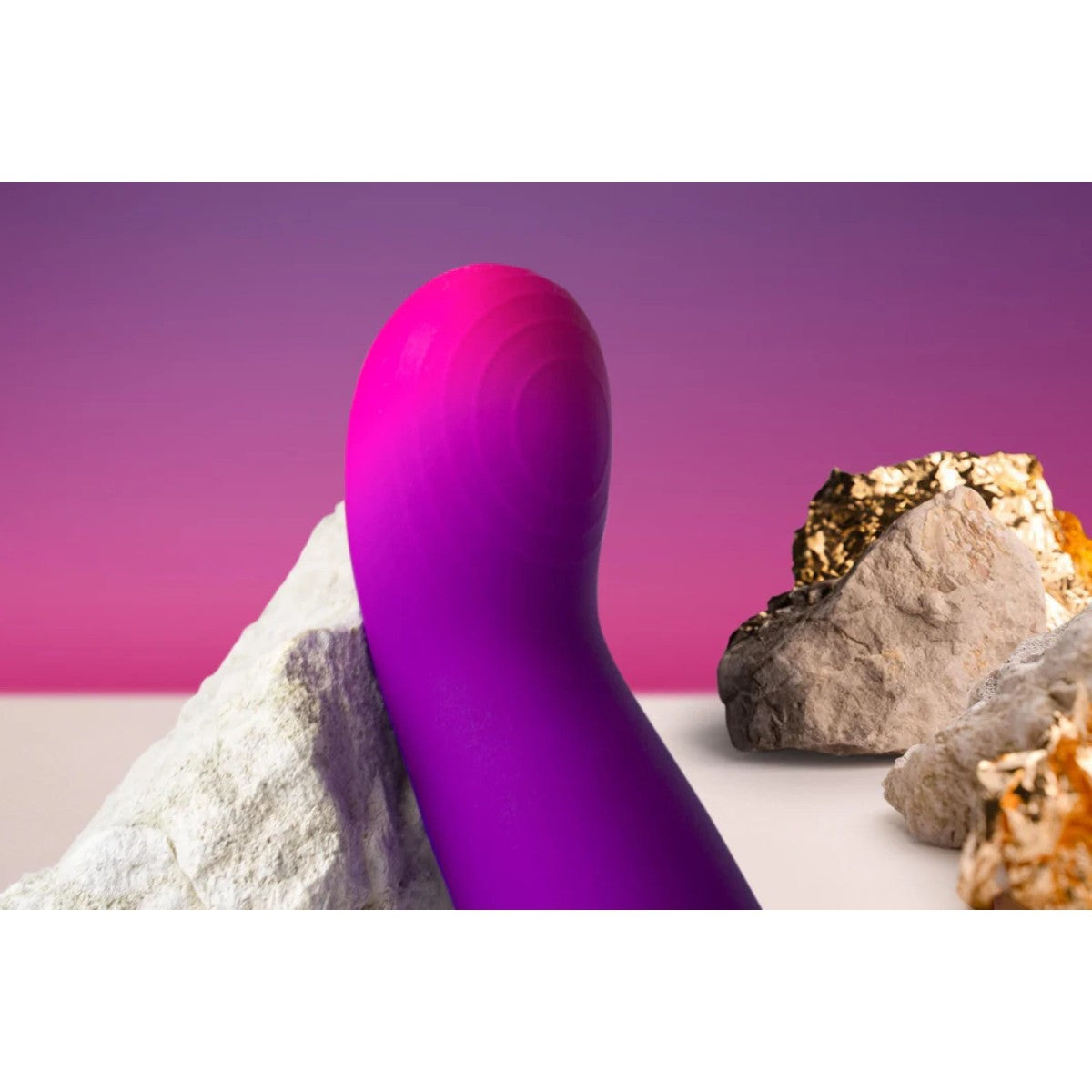 Purple g-spot vibrator on a rock with a pink gradient background