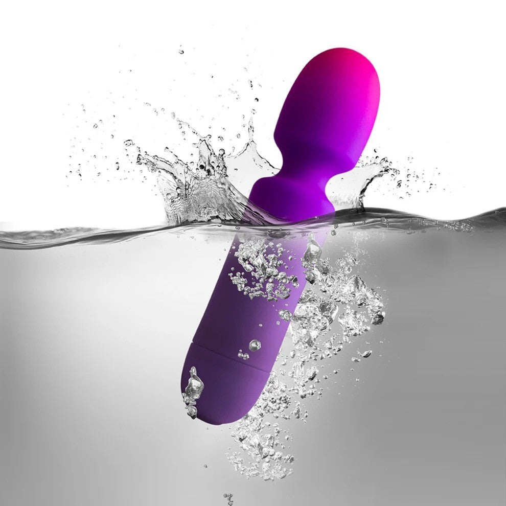 Purple and pink silicone product submerged in water with splashes.