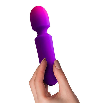 Purple and pink silicone vibrator held by a hand on a white background