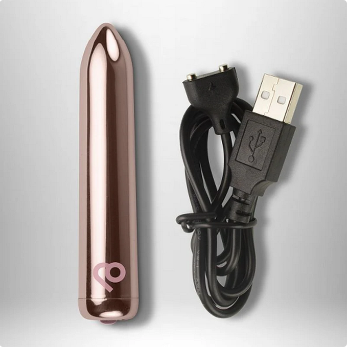 Rose gold electronic device with USB cable on a light gray background