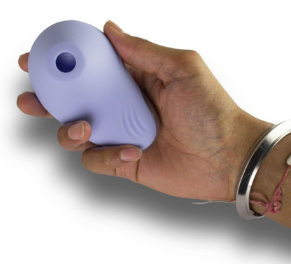Hand holding a purple massager against a white background