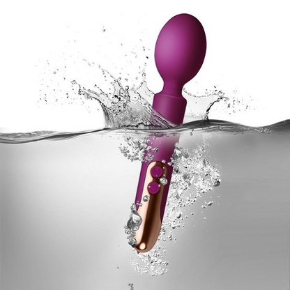 Purple and rose gold electronic device partially submerged in water with water splashes.