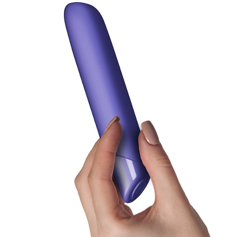 Hand holding a purple bullet vibrator  against a white background