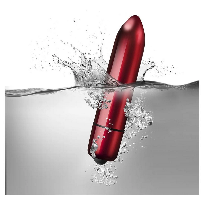 Red electronic massager splashing into water on a white background