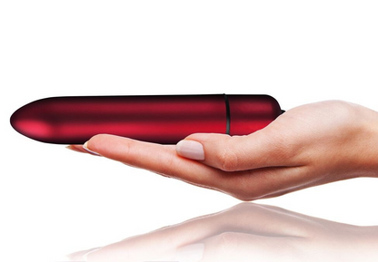 Red cylindrical object held in a hand on a white background