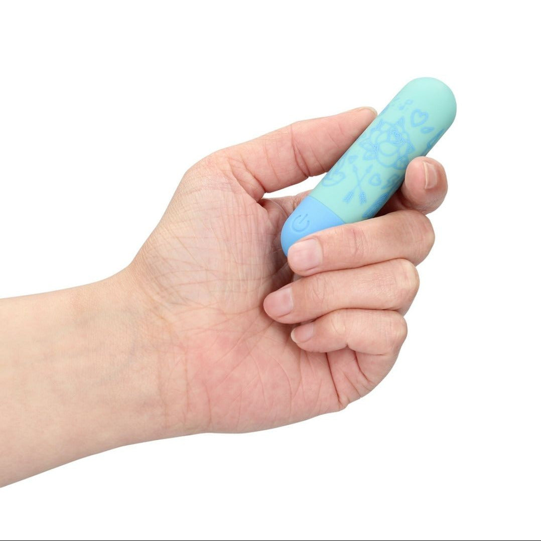 Hand holding a blue and light blue textured vibrator against a white background