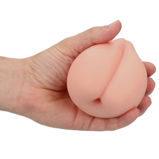 Hand holding a peach-shaped masturbator on a white background