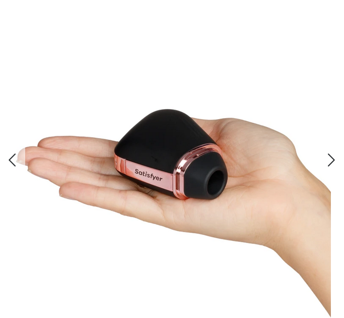 Black Satisfyer product held in a hand on a white background