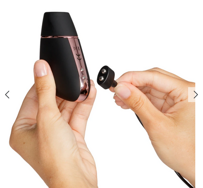 Black electronic device with a small component held by hands against a white background