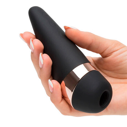 Black and gold electronic device held in a hand with a white background