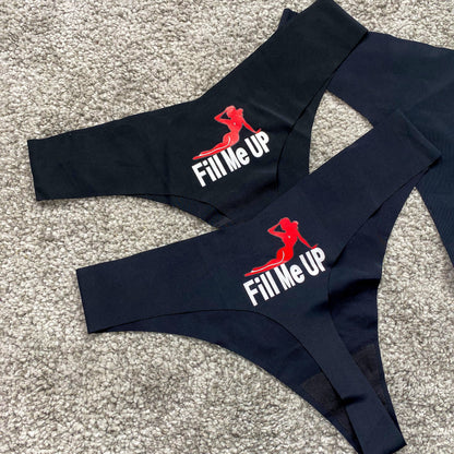 Black swimwear set with 'Fill Me Up' text and logo on a textured surface
