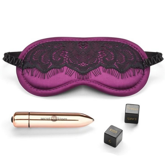 Purple lace eye mask with bullet vibrator and small black dice on a white background