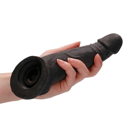 Hand holding a black penis extender sleeve against a white background