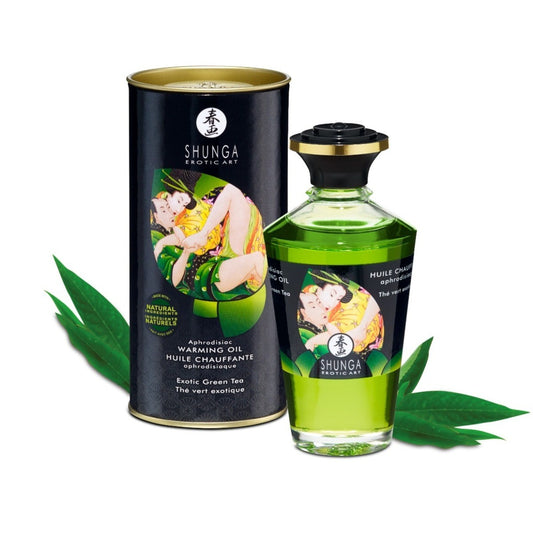 Shunga Exotic Green Tea Warming Oil packaging with green leaves on a white background