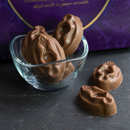 Chocolate candies in a glass bowl with a purple decorative background